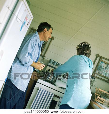 Mature couple in kitchen, woman cooking View Large Photo Image Stock Image - Mature couple in kitchen, woman cooking. Fotosearch