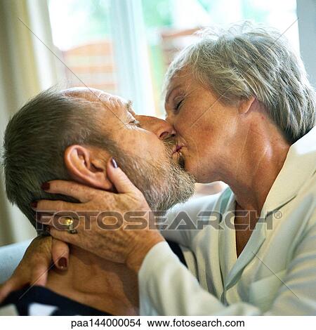 Picture - Mature couple kissing, close-up. Fotosearch