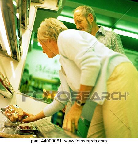 Mature couple looking at groceries in supermarket View Large Photo Image Stock Image - Mature couple looking at groceries in supermarket. Fotosearch
