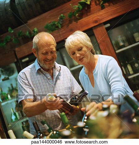 Mature couple looking at wine bottles View Large Photo Image Stock Photograph - Mature couple looking at wine bottles. Fotosearch