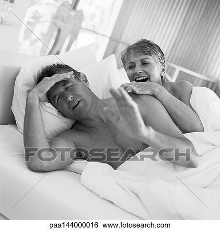 Mature couple lying in bed, man holding head, b&w View Large Photo Image Stock Photograph - Mature couple lying in bed, man holding head, b&w. Fotosearch