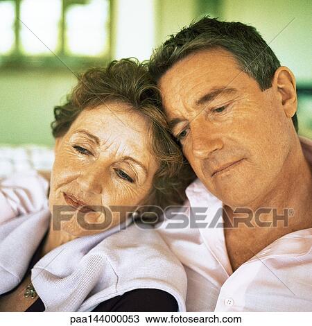 Mature couple sitting with heads together, close-up View Large Photo Image Stock Image - Mature couple sitting with heads together, close-up. Fotosearch