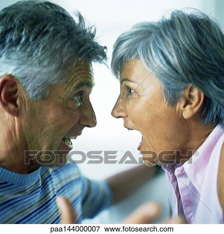 Stock Photo - Mature man and woman having argument, side view. Fotosearch