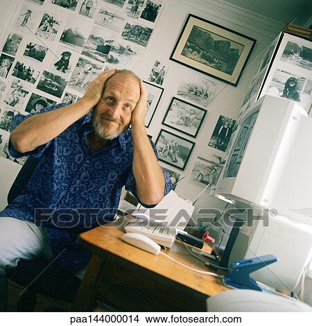 Mature man sitting at computer, hands on head View Large Photo Image Picture - Mature man sitting at computer, hands on head. Fotosearch