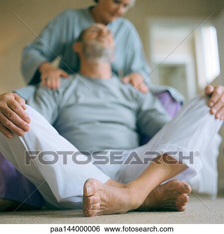 Mature man sitting, woman touching his shoulders View Large Photo Image Stock Photograph - Mature man sitting, woman touching his shoulders. Fotosearch