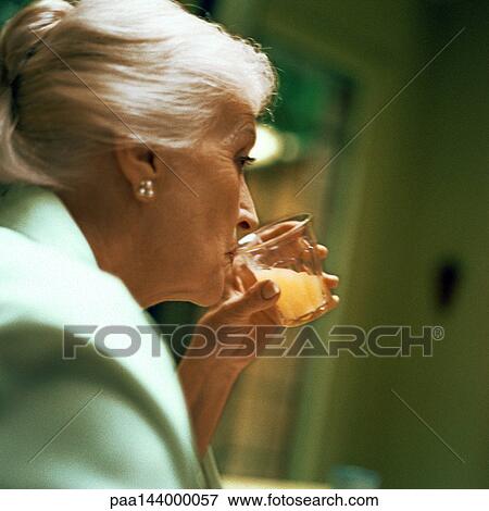 Mature woman drinking, close-up View Large Photo Image Stock Photo - Mature woman drinking, close-up. Fotosearch