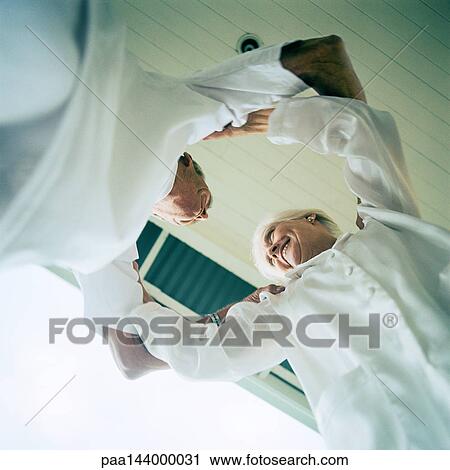 Senior couple holding each other's arms, low angle view View Large Photo Image Stock Image - Senior couple holding each other's arms, low angle view. Fotosearch