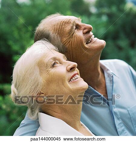 Stock Photography - Senior couple looking up, portrait. Fotosearch