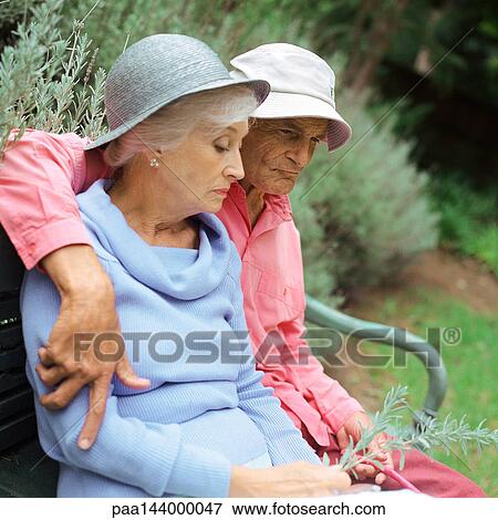 Senior couple sitting on bench outside View Large Photo Image Stock Photo - Senior couple sitting on bench outside. Fotosearch