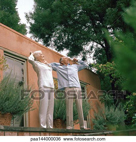 Senior couple stretching in front of house View Large Photo Image Stock Photograph - Senior couple stretching in front of house. Fotosearch