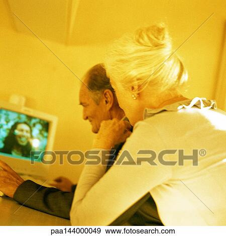 Senior man and woman watching screen, rear view View Large Photo Image Stock Photo - Senior man and woman watching screen, rear view. Fotosearch