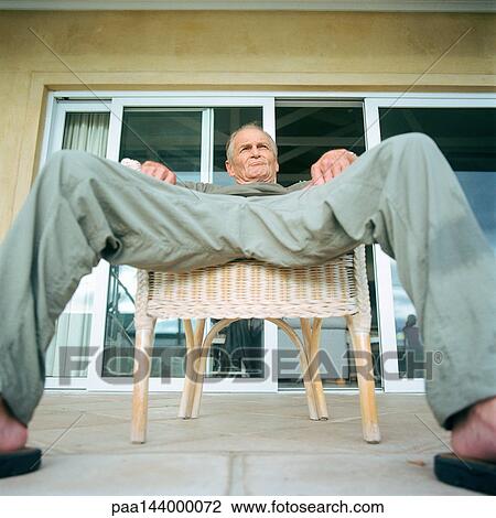 Senior man sitting with legs spread, low angle view View Large Photo Image Stock Image - Senior man sitting with legs spread, low angle view. Fotosearch