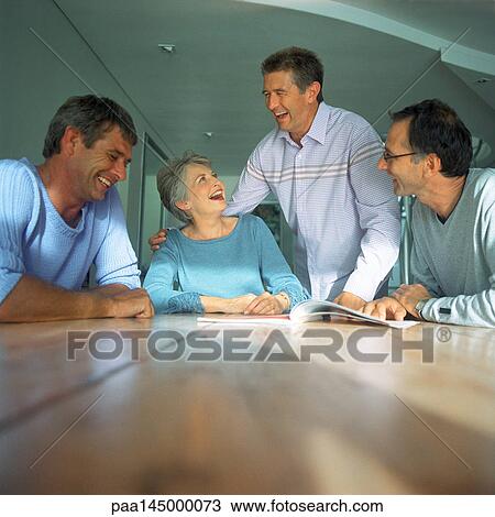 Four people around table View Large Photo Image Stock Image - Four people around table. Fotosearch
