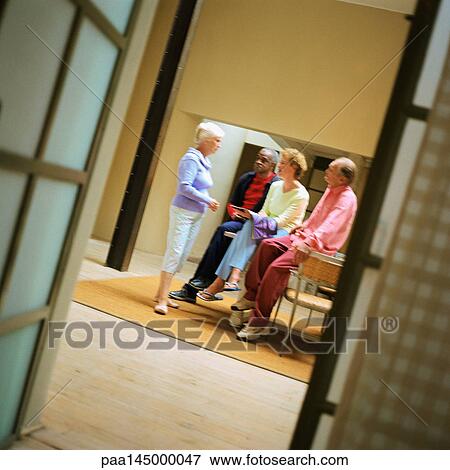Four people standing in room View Large Photo Image Stock Photo - Four people standing in room. Fotosearch