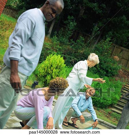 Four people standing in yard View Large Photo Image Stock Photo - Four people standing in yard. Fotosearch