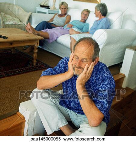 Mature man sitting on floor, three women in background on couch View Large Photo Image Stock Photography - Mature man sitting on floor, three women in background on couch. Fotosearch