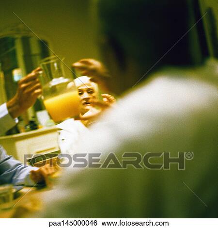 People sitting at table, hand holding pitcher View Large Photo Image Stock Photograph - People sitting at table, hand holding pitcher. Fotosearch