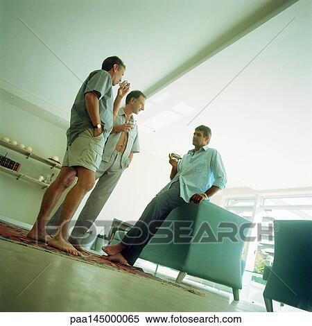 Three mature men having a drink, low angle view View Large Photo Image Stock Photography - Three mature men having a drink, low angle view. Fotosearch