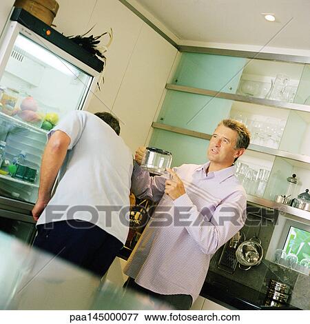 Two men standing in kitchen View Large Photo Image Stock Photo - Two men standing in kitchen. Fotosearch