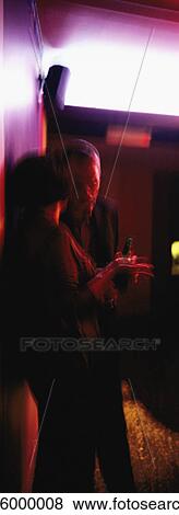 Stock Photo - People leaning against wall, talking, blurred. Fotosearch