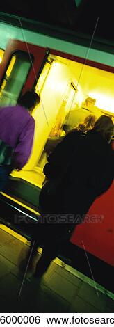 People standing on subway platform next to train at night View Large Photo Image Stock Photograph - People standing on subway platform next to train at night. Fotosearch