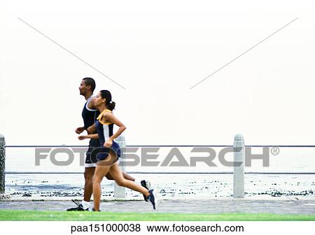 Couple jogging near sea, side view. View Large Photo Image Stock Photo - Couple jogging near sea, side view.. Fotosearch