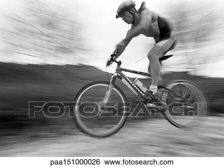 Man cycling, mid-air, blurred, b&w. View Large Photo Image Stock Photograph - Man cycling, mid-air, blurred, b&w.. Fotosearch