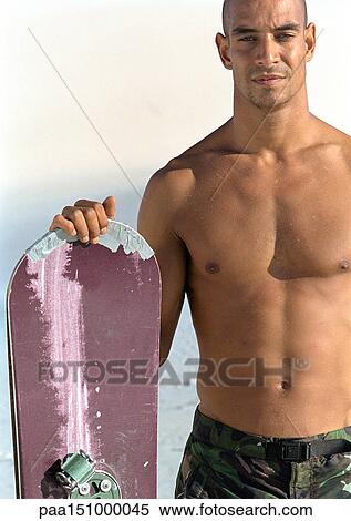 Man holding snowboard, bare-chested, portrait. View Large Photo Image Stock Photography - Man holding snowboard, bare-chested, portrait.. Fotosearch