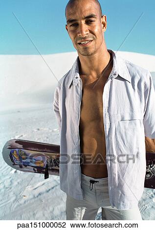 Man looking into camera, holding snowboad, portrait. View Large Photo Image Stock Image - Man looking into camera, holding snowboad, portrait.. Fotosearch