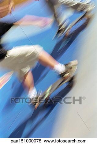 Stock Photo - Two young men on skateboards, low section, blurred.. Fotosearch