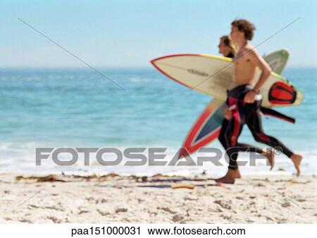 Two young men running with surfboards. View Large Photo Image Stock Image - Two young men running with surfboards.. Fotosearch