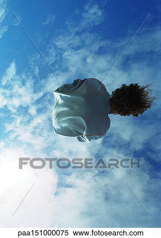 Young man in mid-air, low angle, rear view. View Large Photo Image Stock Photography - Young man in mid-air, low angle, rear view.. Fotosearch
