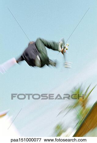 Young man on skateboard, jumping, mid-air, low angle. View Large Photo Image Stock Photo - Young man on skateboard, jumping, mid-air, low angle.. Fotosearch