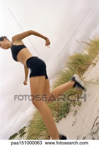 Young woman jogging on beach, low angle view, blurred. View Large Photo Image Stock Image - Young woman jogging on beach, low angle view, blurred.. Fotosearch