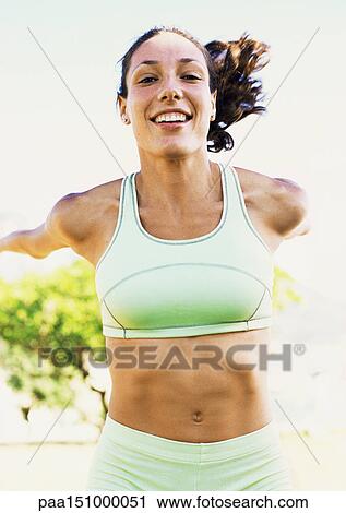Young woman smiling into camera, hands extended behind, portrait. View Large Photo Image Stock Image - Young woman smiling into camera, hands extended behind, portrait.. Fotosearch