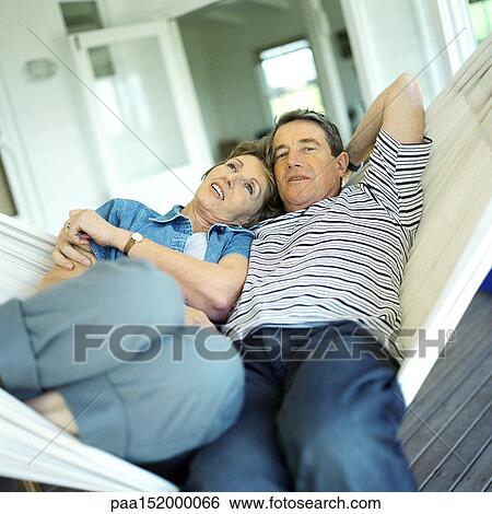 Mature couple lying in a hammock. View Large Photo Image Stock Photograph - Mature couple lying in a hammock.. Fotosearch
