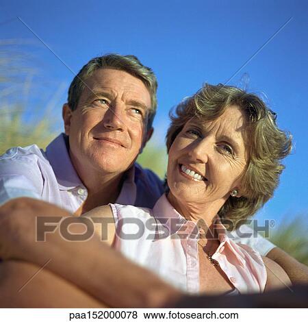 Stock Photo - Mature couple, man's arms around woman.. Fotosearch