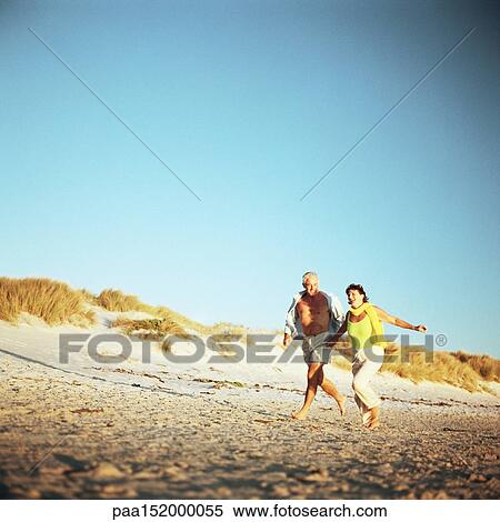 Mature couple running on beach. View Large Photo Image Stock Photography - Mature couple running on beach.. Fotosearch