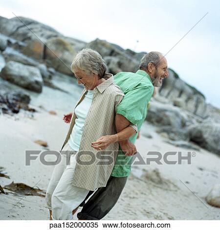 Mature couple standing back to back, arms locked, side view. View Large Photo Image Stock Photography - Mature couple standing back to back, arms locked, side view.. Fotosearch