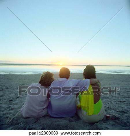 Mature friends sitting on beach, rear view. View Large Photo Image Stock Photo - Mature friends sitting on beach, rear view.. Fotosearch