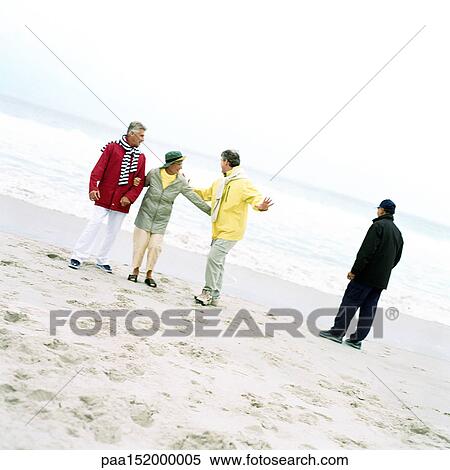 Stock Photography - Mature group on beach by the sea.. Fotosearch
