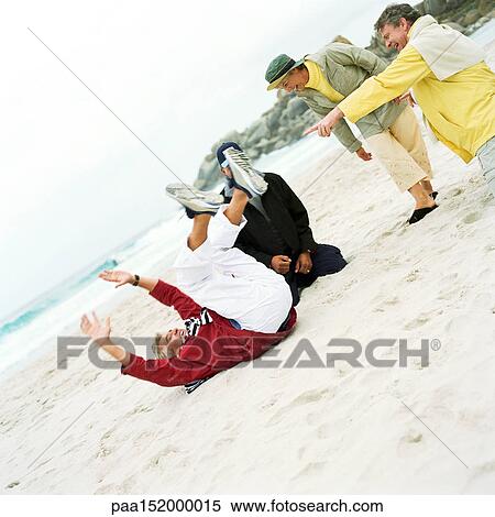 Stock Photography - Mature group playing on beach.. Fotosearch