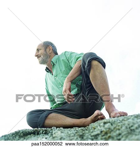 Mature man sitting on rocks, low angle view. View Large Photo Image Stock Image - Mature man sitting on rocks, low angle view.. Fotosearch