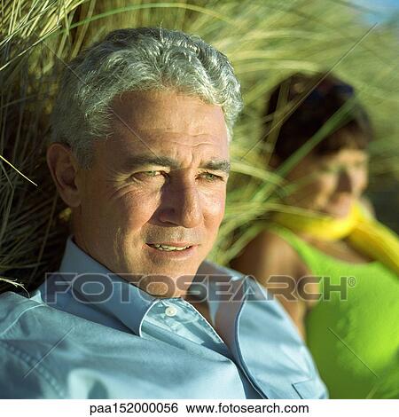 Mature man, woman blurred in background View Large Photo Image Stock Photograph - Mature man, woman blurred in background. Fotosearch