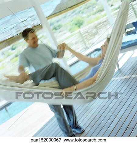 Mature woman laughing in hammock, mature man grabbing her leg and arm, blurred. View Large Photo Image Stock Photo - Mature woman laughing in hammock, mature man grabbing her leg and arm, blurred.. Fotosearch