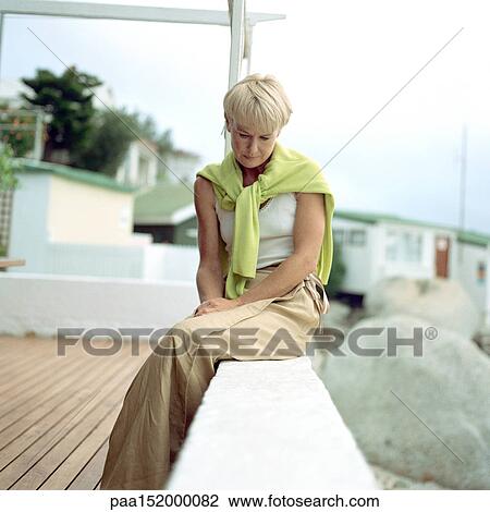 Mature woman sitting, looking down. View Large Photo Image Stock Image - Mature woman sitting, looking down.. Fotosearch