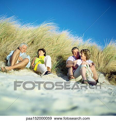 Two mature couples sitting on beach. View Large Photo Image Stock Photo - Two mature couples sitting on beach.. Fotosearch