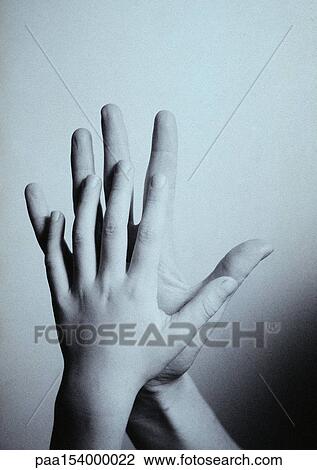 Stock Image - Child's hand touching man's hand, palm to palm, close-up, b&w.. Fotosearch