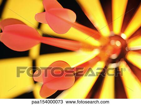 Stock Image - Darts in bullseye of dartboard, close-up.. Fotosearch