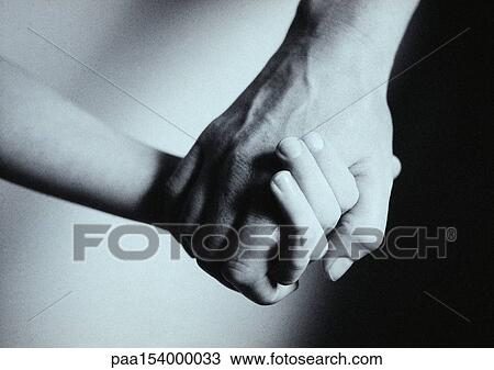 Stock Image - Man and child holding hands, close-up, b&w.. Fotosearch